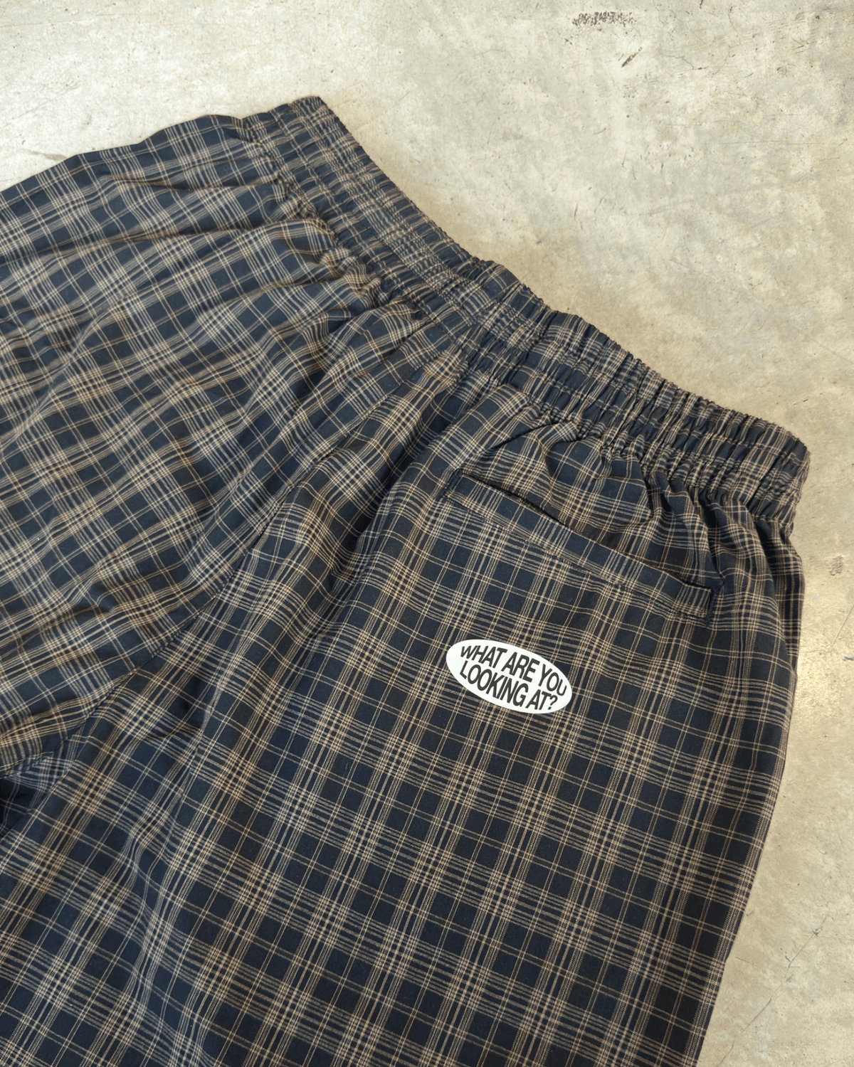 Détail de la taille élastique et du logo brodé du CHECKMATE PANT MUZO