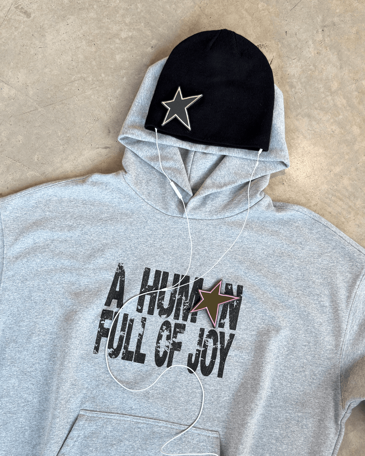 Bonnet STAR BEANIE noir posé sur le JOY HOODIE MUZO